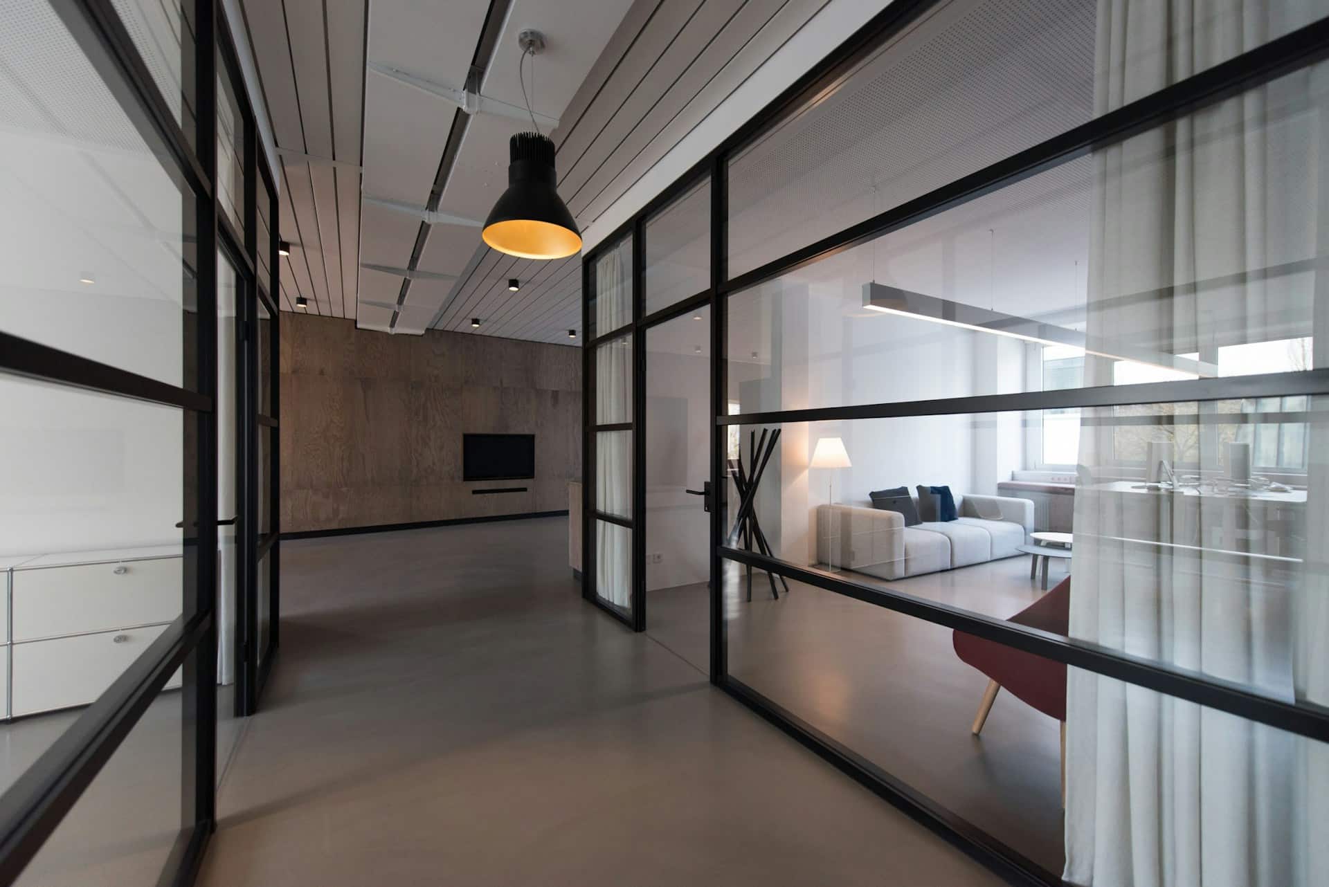 A modern office corridor with glass-walled workspaces